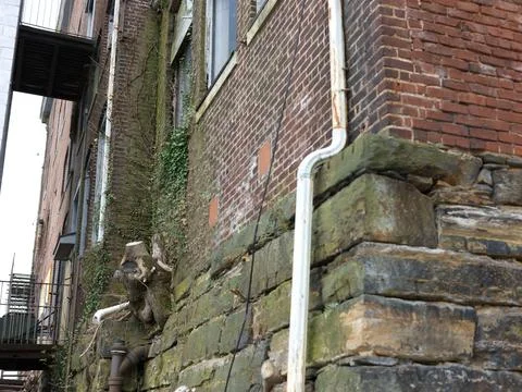 A white pipe on the side of a brick building Fotos de archivo