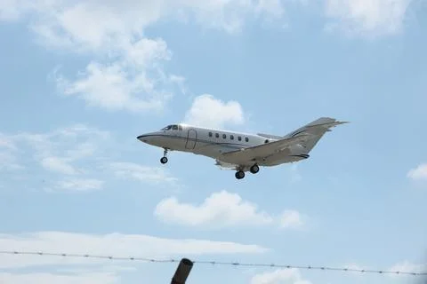 White Plane Approaching Runway with Cloudy Sky Background Stock Photos