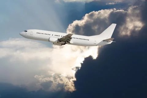 White plane with dark clouds Stock Photos