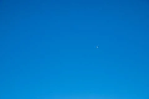 White plane in a deep blue sky Stock Photos