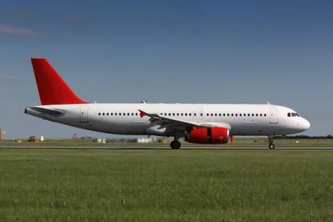 White plane with red tail after landing Stock Photos