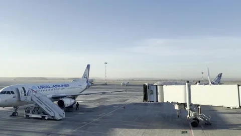 A white plane with the word "URAL" on the side sits on the tarmac Stock Footage 274537420