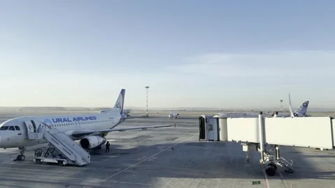 A white plane with the word "URAL" on the side sits on the tarmac 库存影片 277566868