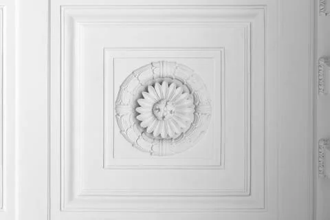 White plaster ceiling rosette surrounded by layered decorative molding Stock Photos