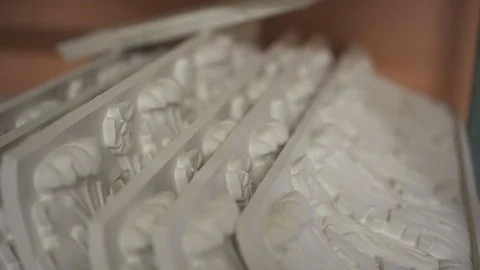 White plaster decorations are laying on table in light workshop. Stock Footage 92326977