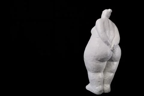 White Plaster Lady Standing Back on Black Solid Background with Copy Space Stock Photos