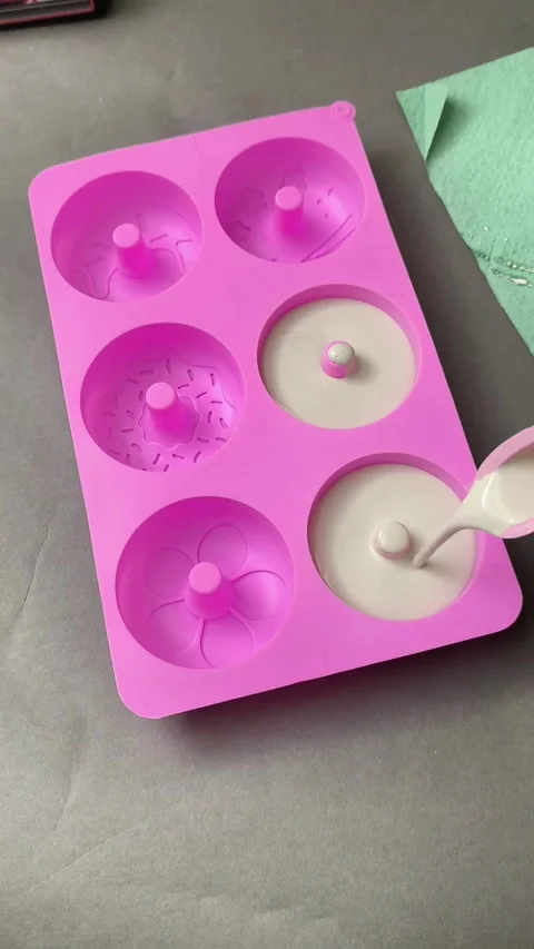 White plaster mixture flowing into circular silicone tray during artisan Stock Footage 342266927