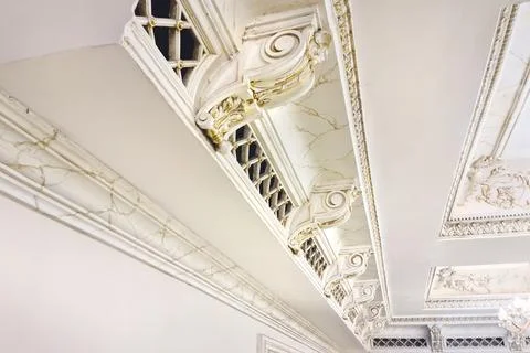 White plaster molding elements with gold veins for decorating the ceiling in a Foto stock