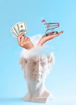 White plaster statue head with hand holding money and shopping cart on blue.. Stock Photos