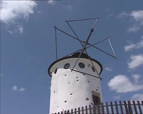 White plastered stone windmill against blue sky Video stock 190987050