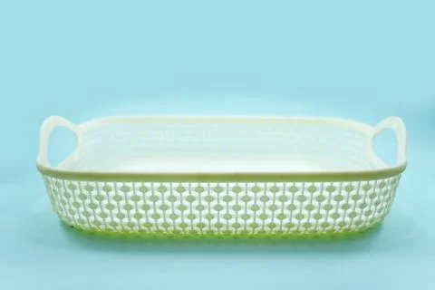 White plastic basket with woven pattern isolated on a turquoise Stock Photos