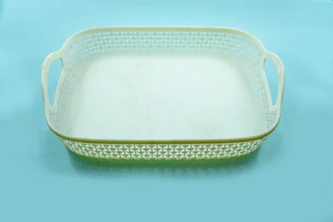 White plastic basket with woven pattern isolated on a turquoise Stock Photos