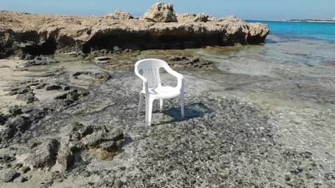 A white plastic beach chair sits in the water. Cyprus. Ayia Napa. Stock Footage 154392825