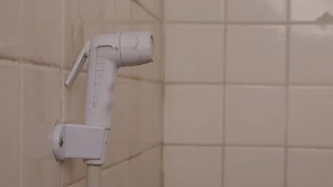 White plastic bidet hand shower sprayer on bathroom wall Video stock 331706512