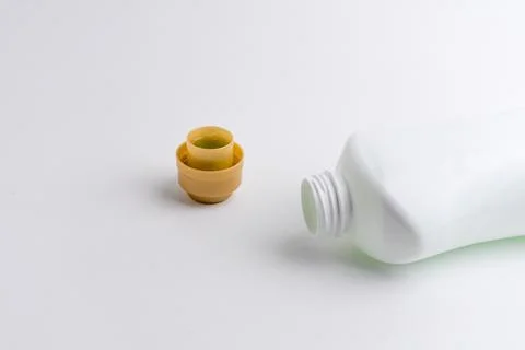 White plastic bottle with open small cap isolated on white background Stock Photos