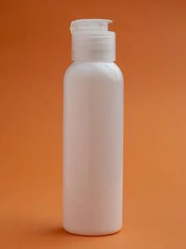 White Plastic bottle on a orange background. skin, body care. copy space. p.. Fotos Stock