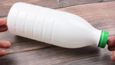 White plastic bottle on a wooden table. White bottle of milk products. Stock Footage 210929530