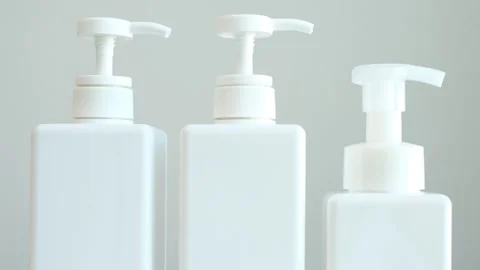 White plastic bottles with detergents on gray background side view. Stock Footage 303878240