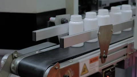 White plastic bottles fall from conveyor belt of blow molding machine - close up Stock-Footage 344601838
