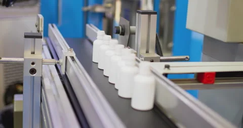 White plastic bottles moving on conveyor belt in factory Stock Footage 302261142