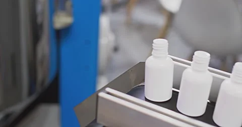 White plastic bottles moving on conveyor belt in factory Stock Footage 302261689