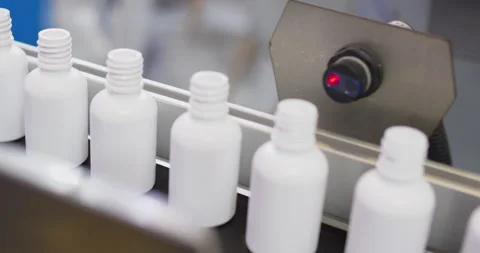 White plastic bottles moving on conveyor belt in factory Stock Footage 303633244