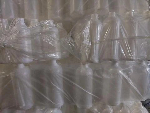 White Plastic Bottles Wrapped in Transparent Plastic Packaging Stock Photos