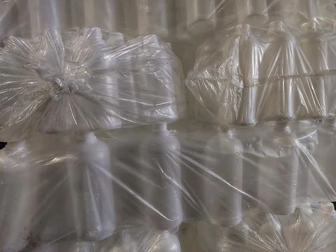 White Plastic Bottles Wrapped in Transparent Plastic Packaging Stock Photos