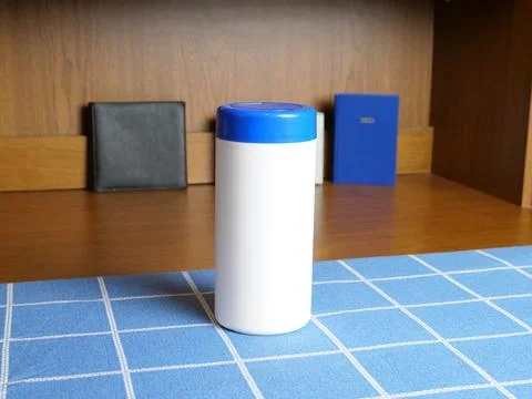 White plastic container with blue lid standing on table with cutting mat Stock Photos