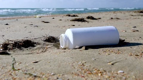 A white plastic container on a sandy beach. Stockbeeldmateriaal 170484647