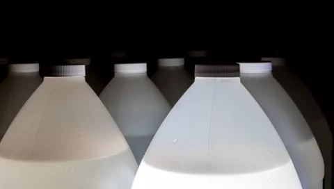 White plastic containers full of fluid with lids Stock Photos