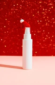 White plastic cosmetic bottle with tiny hat on pink red background Stock Photos