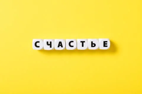 White plastic cubes with letters composed the word happiness. Stock Photos