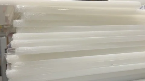 White plastic cutting boards stacked on a retail store counter displaying Stock Footage 345179145