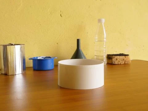 White plastic cylindrical container standing on wooden table among household  Stock Photos