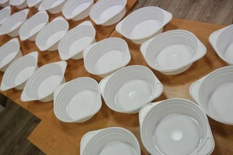 White plastic deep disposable plates stand on a wooden table. zero weist, rec Stock Photos