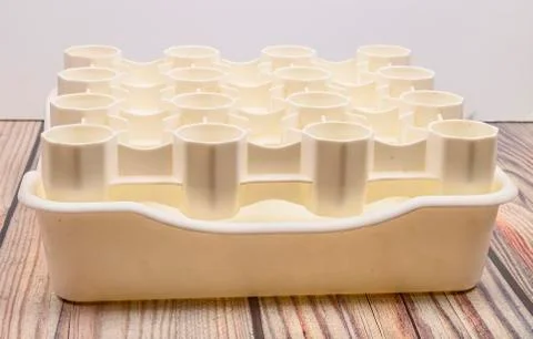 White plastic drying rack for the bottles on the wooden table. Stock Photos