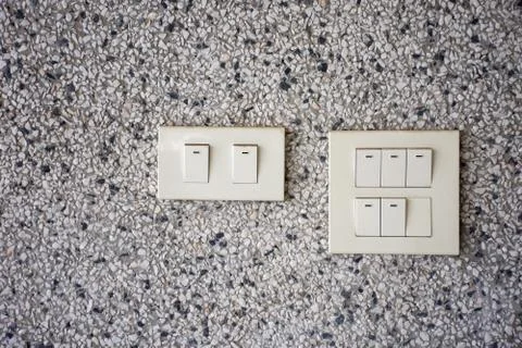 White plastic electrical switch On the marble wall Stock Photos