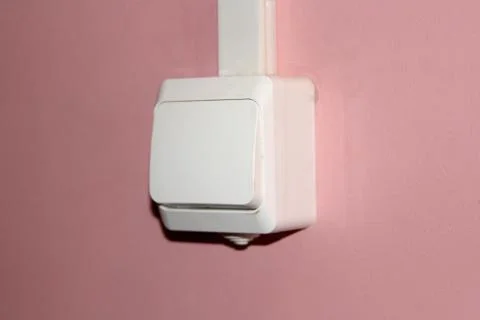 White plastic electrical switch on a pink wall Stock Photos