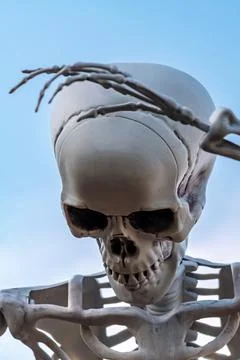 White plastic human skeleton prop raised arm against clear blue sky backgro.. Stock Photos