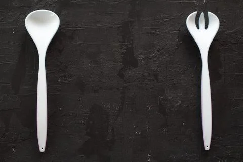 White plastic kitchen fork and spoon isolated on black background Stock-Fotos