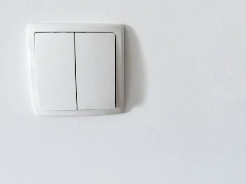 White plastic light switch on clean white wall interior detail minimal conc.. Foto stock