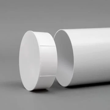 White plastic pipe with a plug on a gray background. Round shape. Stock Photos