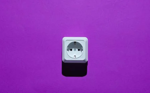 White plastic power socket on purple background. Minimalism Stockfoto's