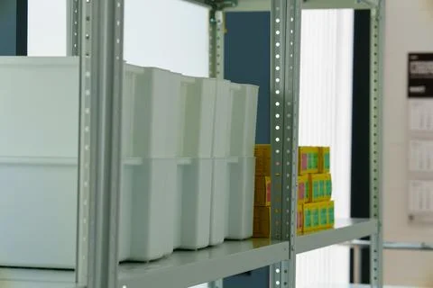White plastic storage containers on a shelf in a medical clinic 스톡 사진