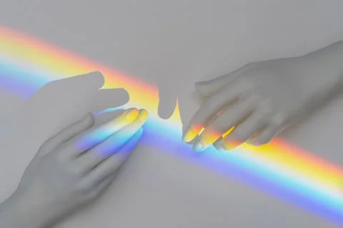 White plastic toys hands with lgbt flag colors between them Stock Photos