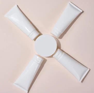White plastic tubes, jars and other form of packaging for cosmetics on a b... Stock Photos