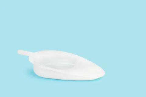 White plastic urinary bedpan on a light blue background with copy space Foto stock