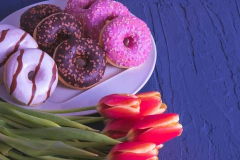 On a white plate are donuts of different colors and tastes Stock Photos