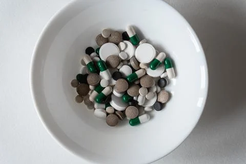 White plate with Different tablets and pills at white background Stock Photos